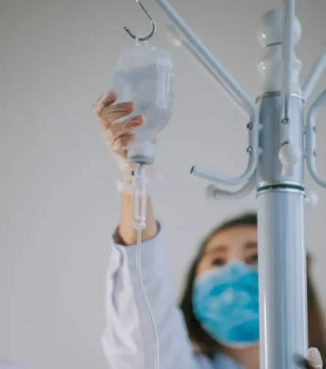 медсестра держит капельницу