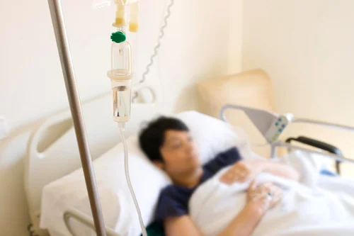 женщина лежит под капельницей с аскорбиновой кислотой